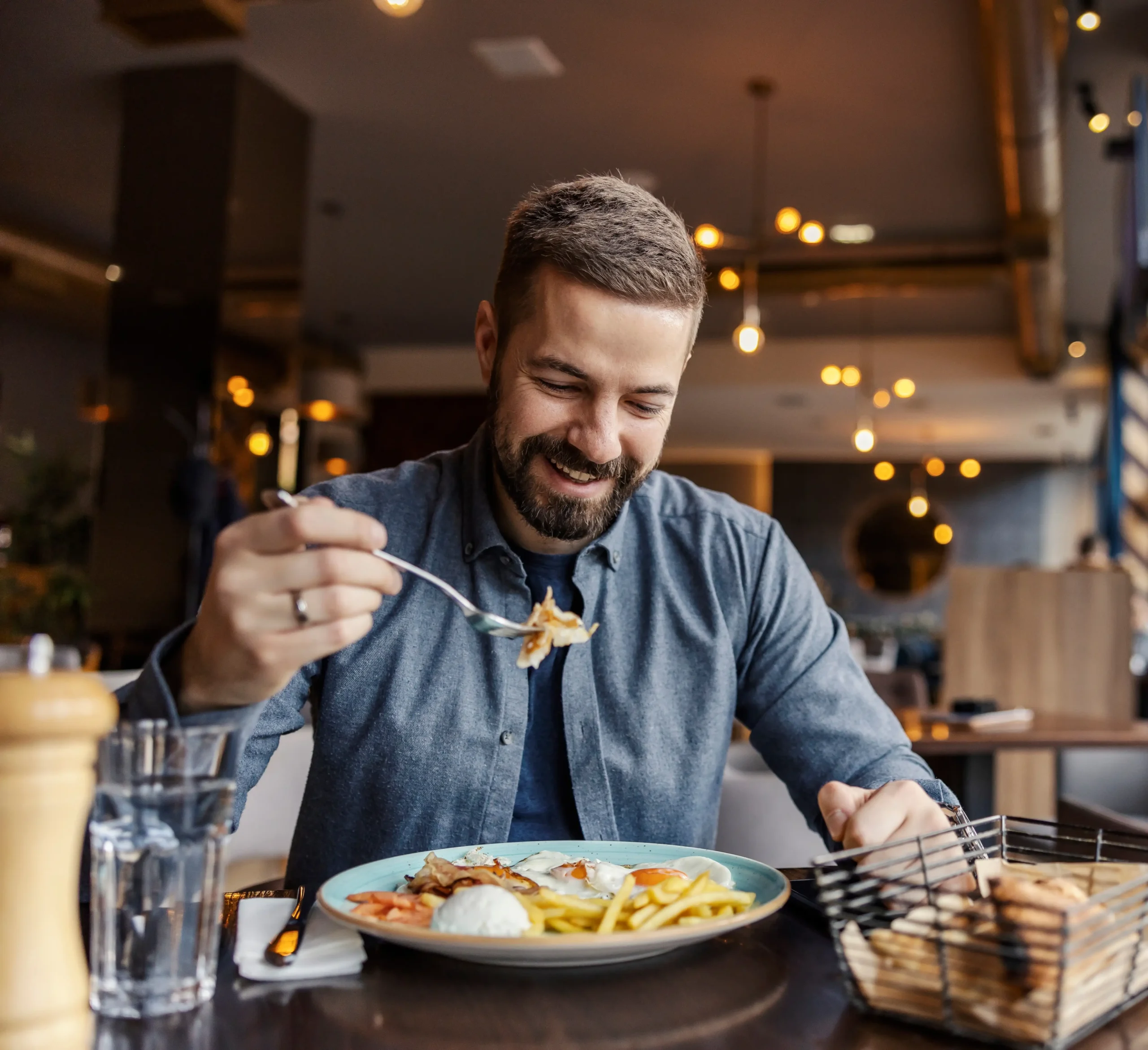hombre sonriendo mientras observa su plato de comida